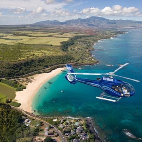 Soaring above a beach during 45 minutes Molokai helicopter tours in Maui.