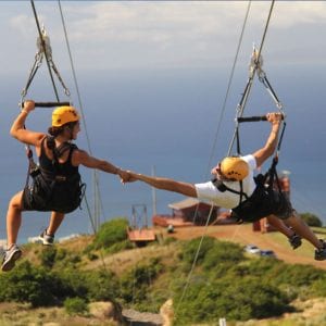 A thrilling moment on the Kapalua zipline tour in Maui, as couple glide above with stunning views.