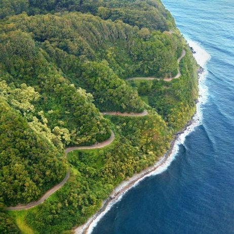 The scenic winding road on a hillside on the Road to Hana adventure in Maui.