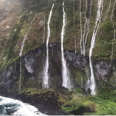 A bird's view of a majestic waterfall during Maui helicopter tour.